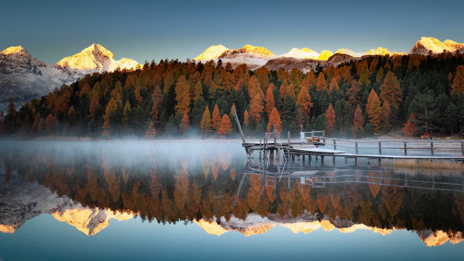 Stazersee mit Bootssteg im Herbstnebel über dem Wasser